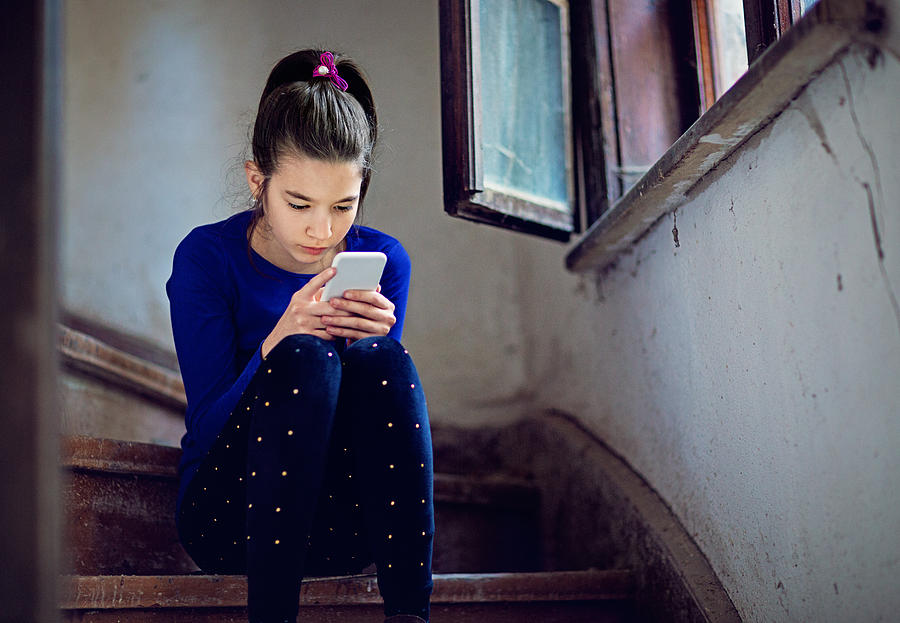 Nostalgic young girl is texting on the stairs Photograph by Praetorianphoto