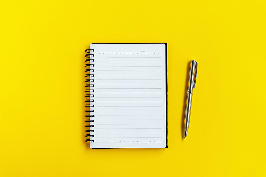 Note Pad and Pen on Yellow background Photograph by Nora Carol Photography