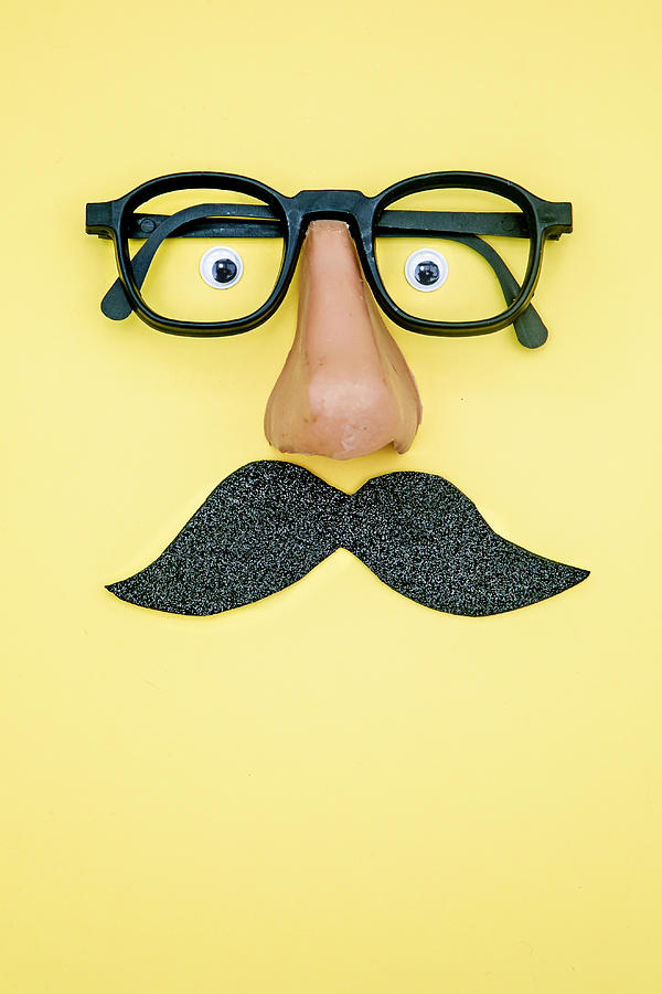novelty glasses with fake moustache and googly eyes.Yellow background Photograph by Carol Yepes