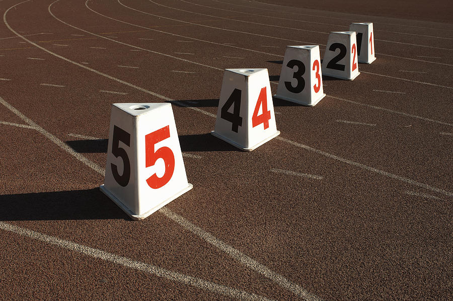 Numbered lane markers on running track Photograph by Black 100