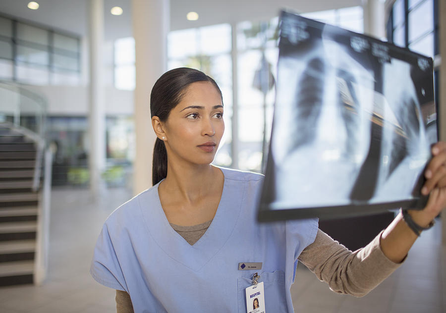 Nurse examining chest x-rays in hospital Photograph by Paul Bradbury
