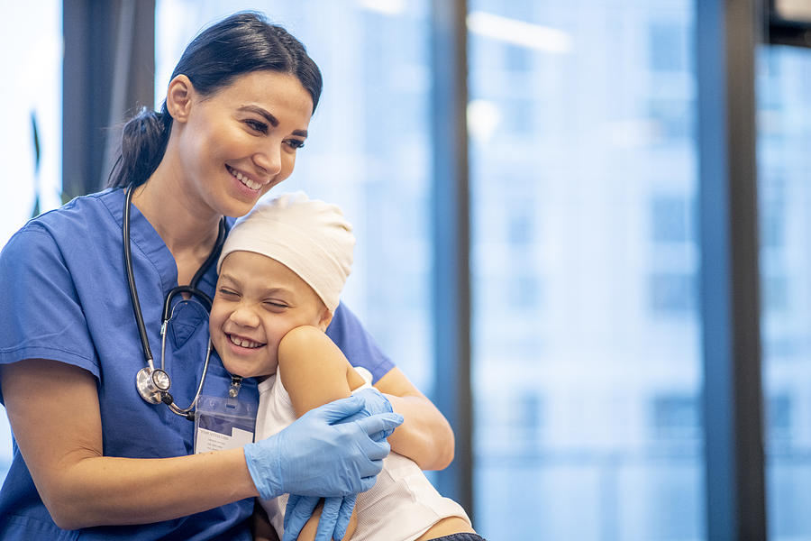Nurse Hugging Young Cancer Patient stock photo Photograph by FatCamera