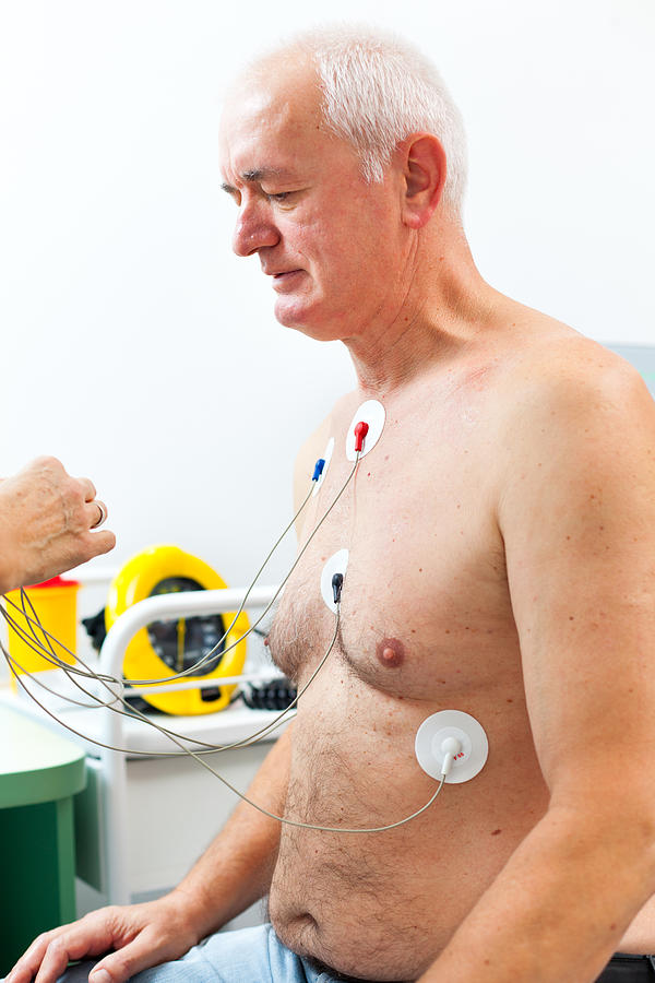 Nurse placing Holter monitor on patients chest Photograph by Fotostorm