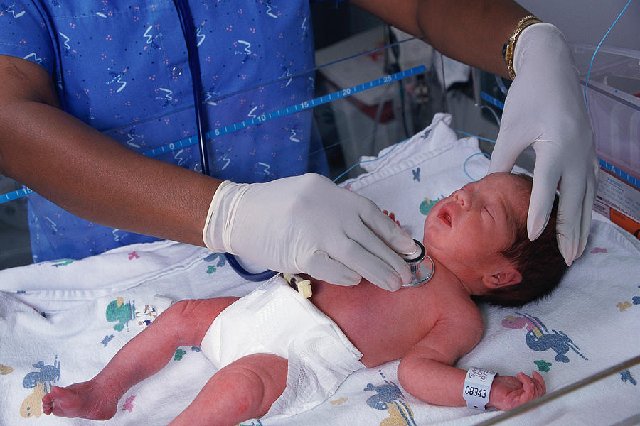Nurse tending to newborn Photograph by Diane Macdonald