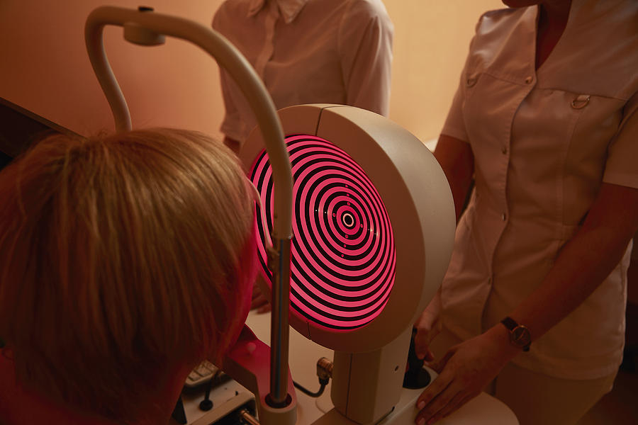 Nurses examining patient with corneal topographer in hospital Photograph by Alexandr Sherstobitov