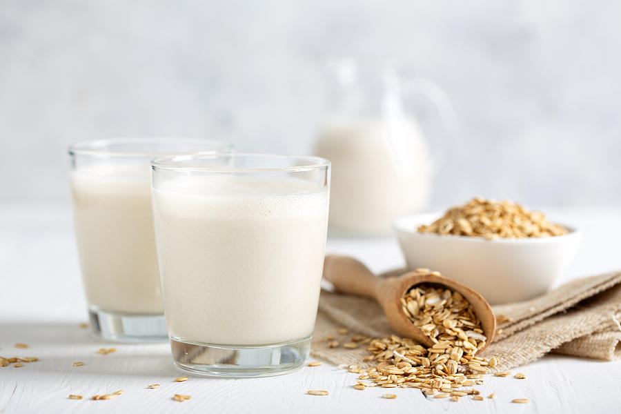 Oat milk. Healthy vegan non-dairy organic drink with flakes Photograph by YelenaYemchuk