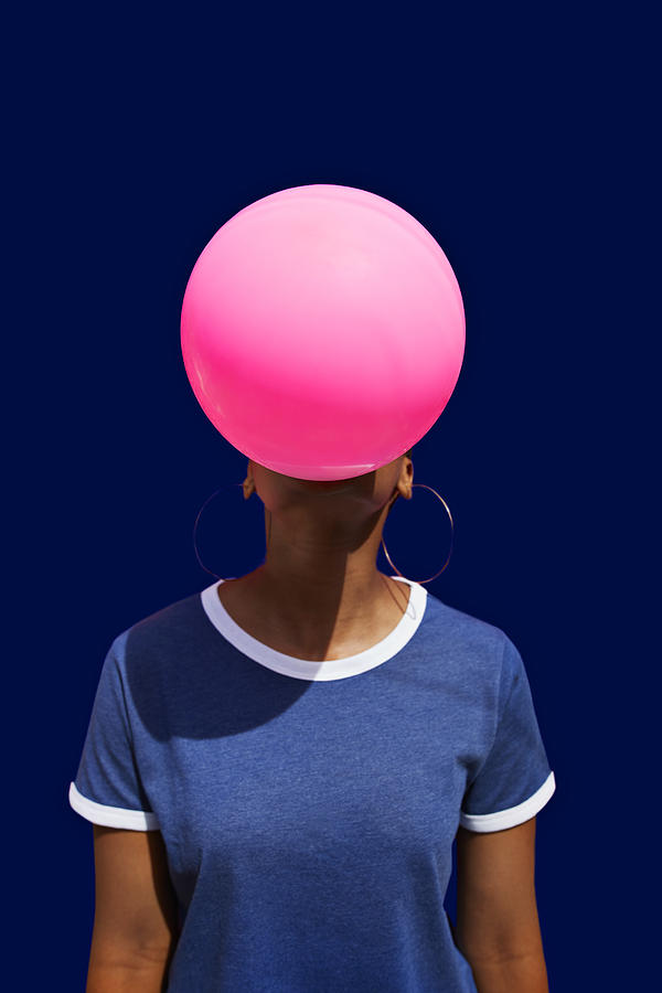 Obscured face of woman blowing balloon Photograph by Klaus Vedfelt