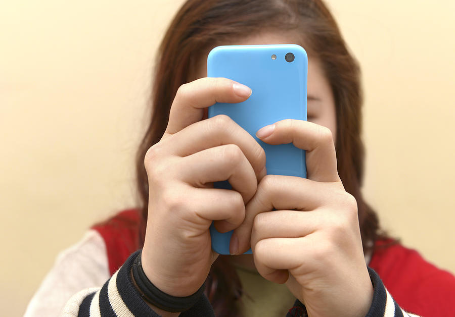 Obsessive Teenager Texting On Smart Phone Photograph by Peter Dazeley