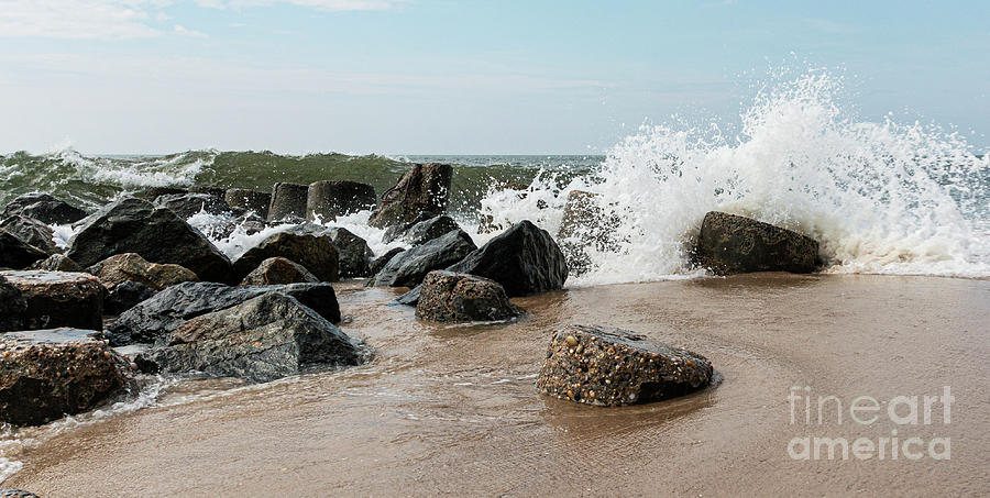 sea with big waves crashing to shore and rocks