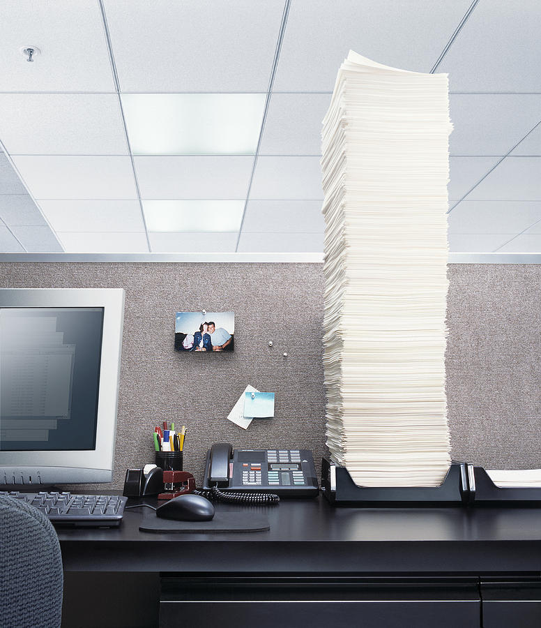 Office desk with papers piled high in In box Photograph by Stephen Swintek