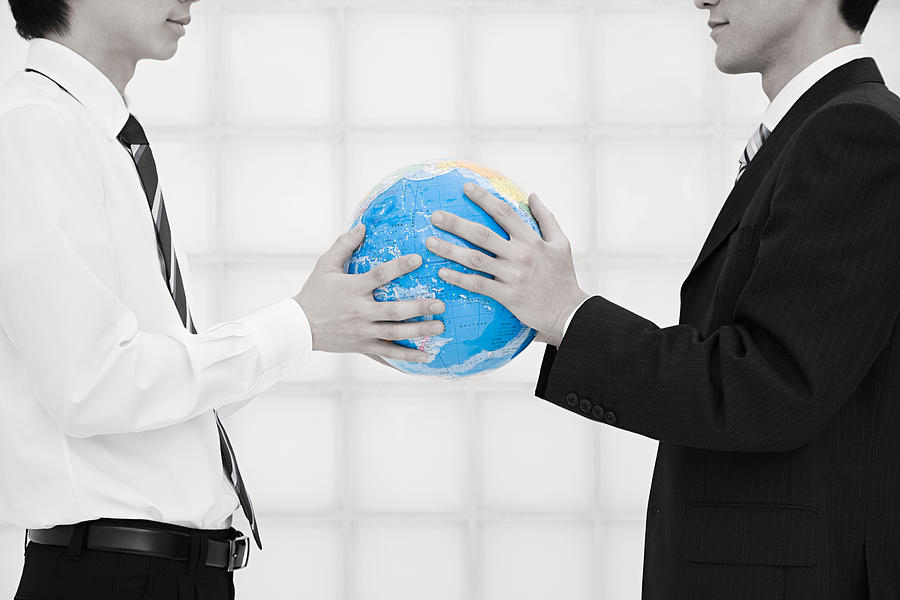 Office workers holding globe Photograph by Image Source