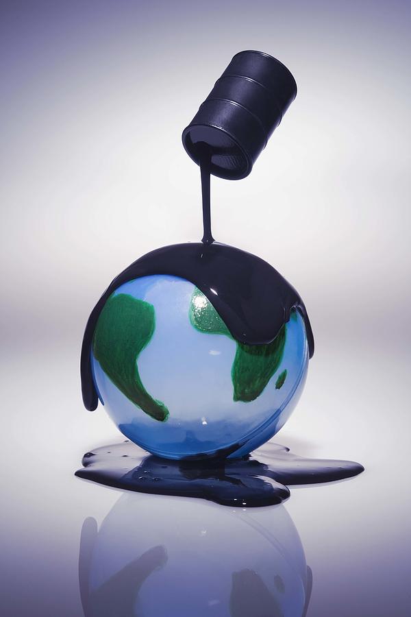 Oil pouring over Earth Photograph by Jupiterimages