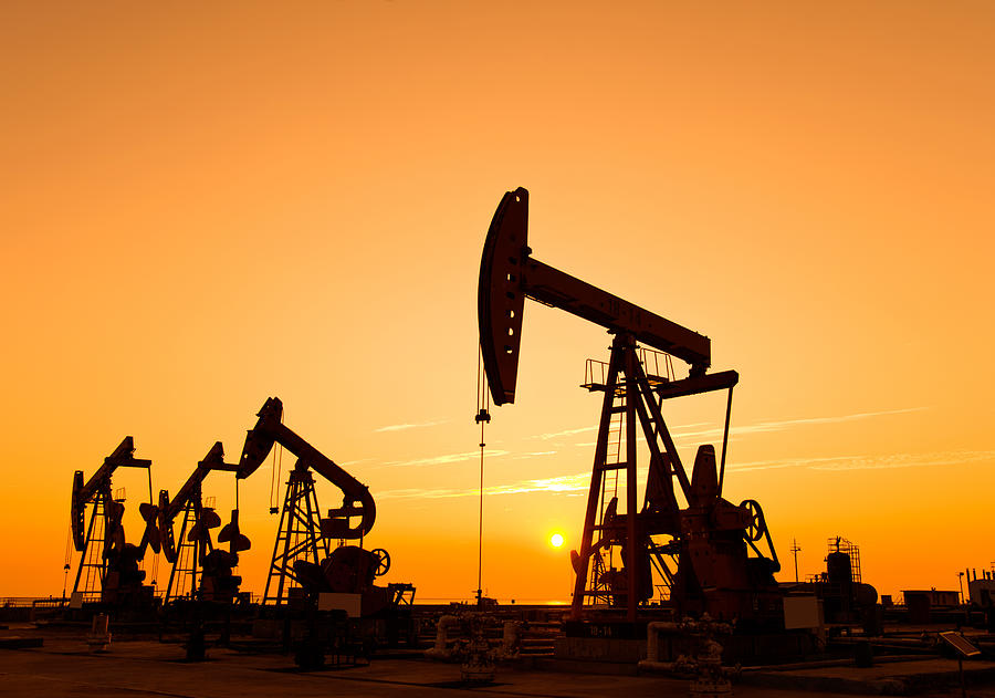 Oil pumps and rig at sunset Photograph by Baona