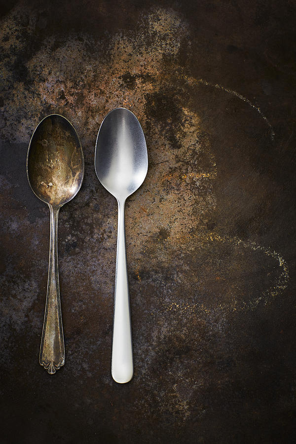 Old and modern spoon side by side on rusty ground Photograph by Westend61