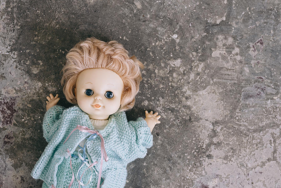 Old Doll Abandoned On A Concrete Floor Photograph by Gillian Vann