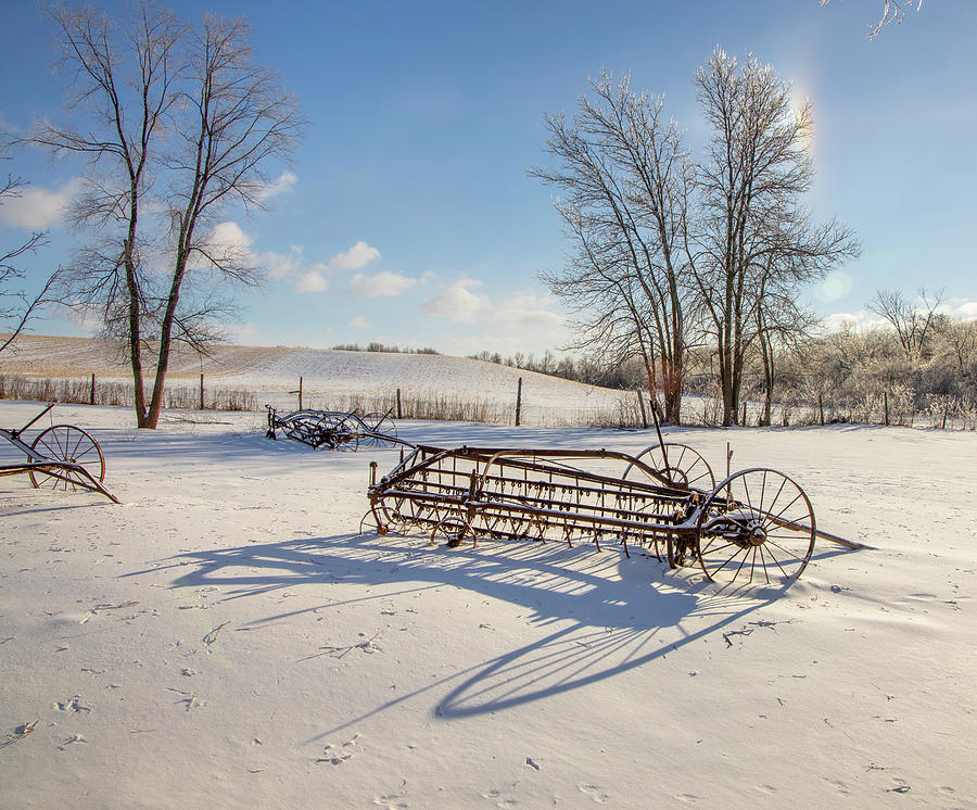 Old farm machinery casting long shadows on snow Photograph by James ...