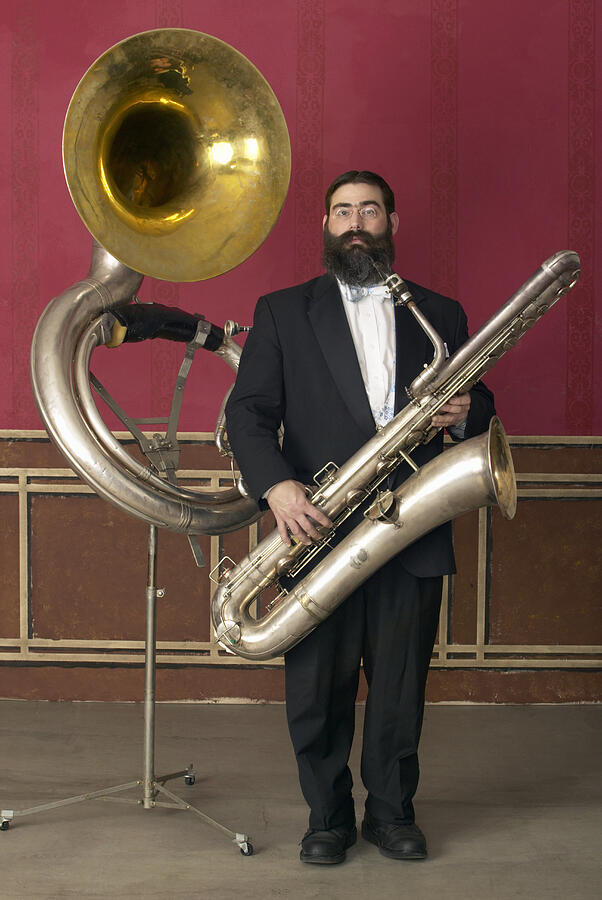 Old Fashioned Man in a Suit Holding a Large Saxophone, Standing Next to a Tuba on a Music Stand Photograph by Gregory Costanzo