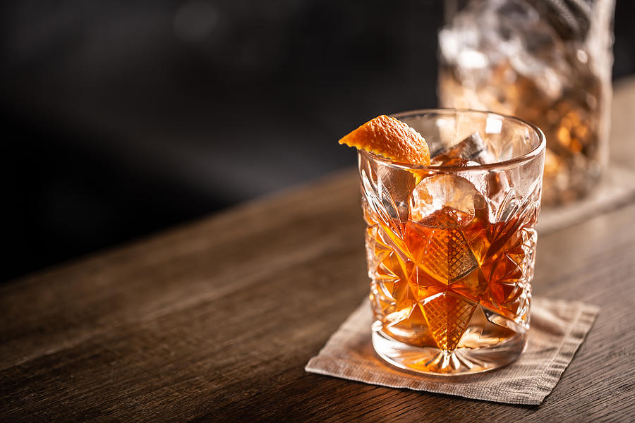 Old fashioned whiskey drink on ice with orange zest garnish. Photograph by SimpleImages