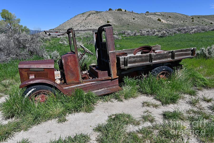 Old International truck sitting in a field behind the Ghost Town in Bannack, Montana. Photograph by Steve Brown