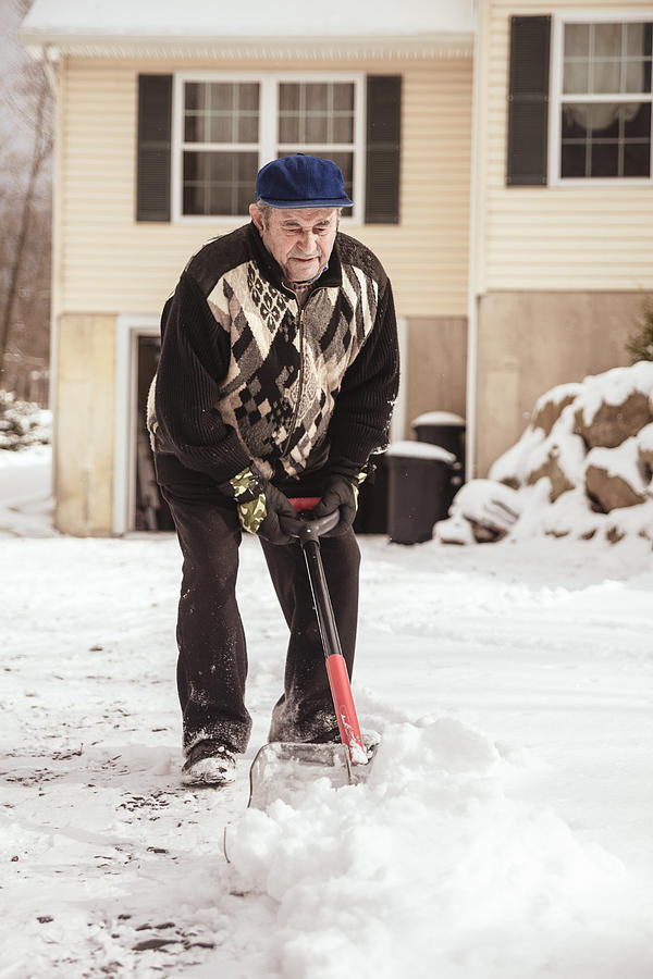 Old man cleaning doorway before house from snow after snowfall Photograph by Alex Potemkin