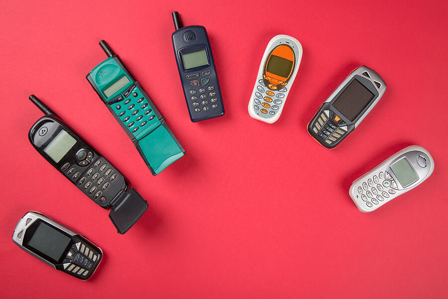 Old mobile phones on red background Photograph by Nantonov
