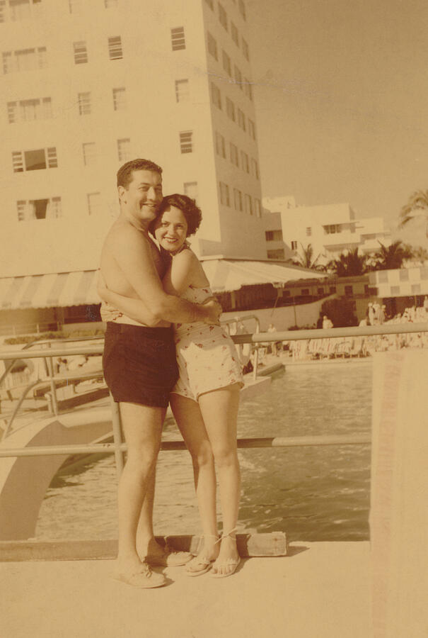 Old Photograph of a Couple Embracing by a Swimming Pool Photograph by Digital Vision.