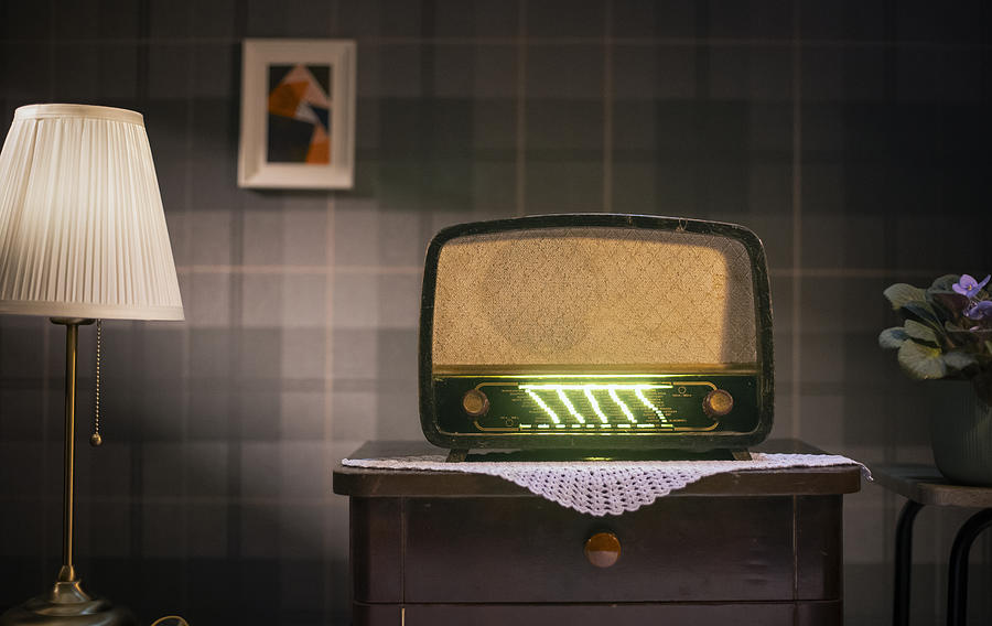 Old retro radio on table against vintage wall background Photograph by Nemke