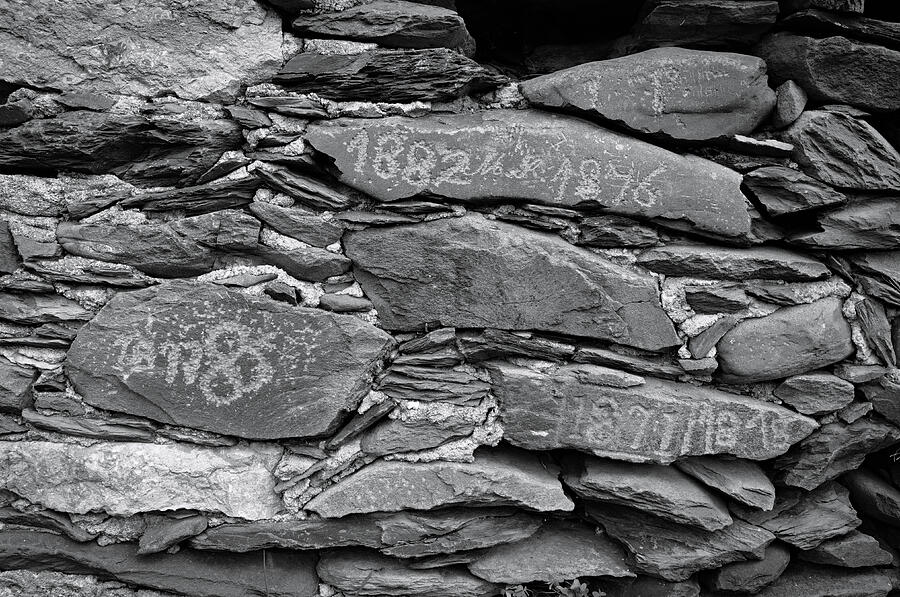 Black And White Photograph - Old schist wall with several dates from 19th century. Portugal by Angelo DeVal