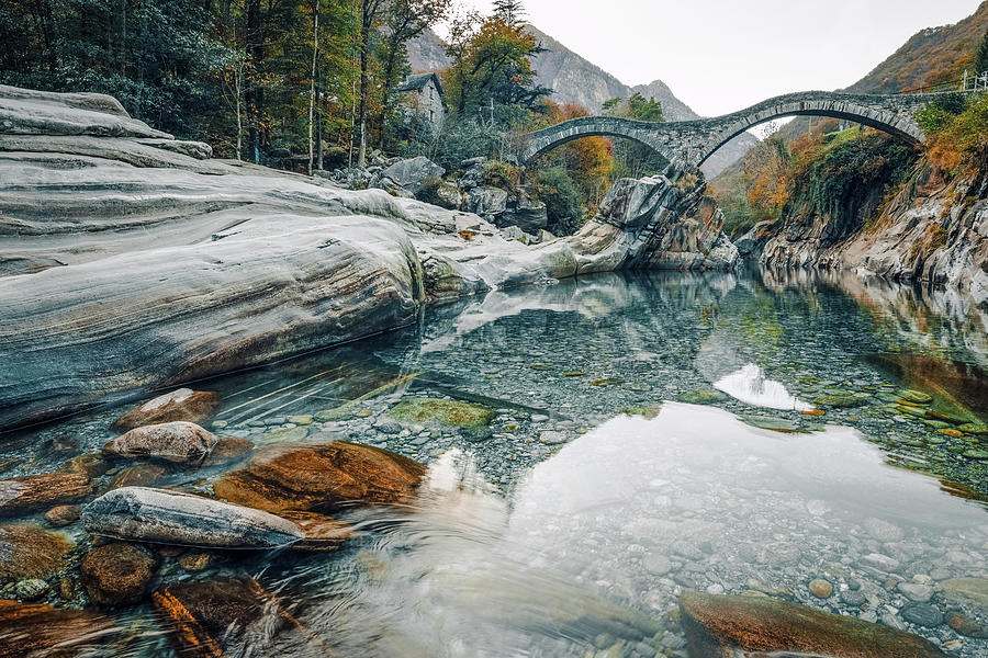 Old stone bridge over crystal clear water Photograph by Benoit Bruchez