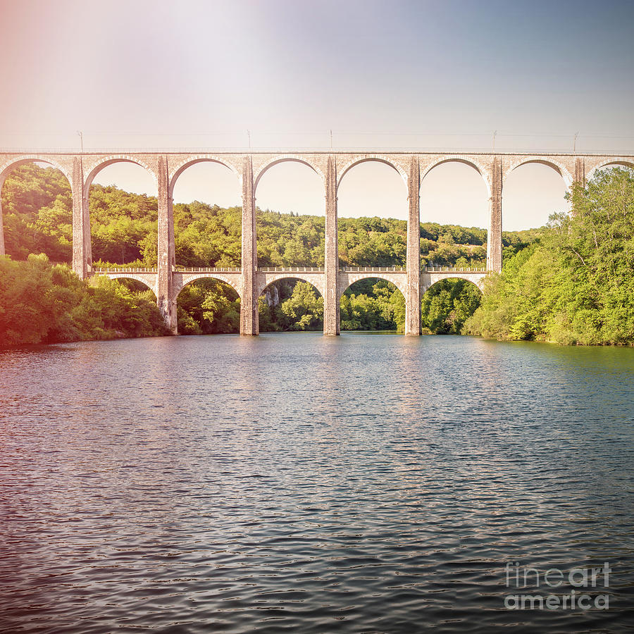 Old stone viaduct over large river between two hills sunset Photograph by Gregory DUBUS