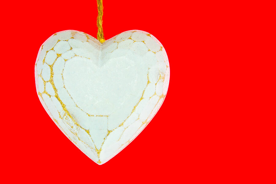 Old worn white wooden heart isolated on red background Photograph by Alexander_Photo