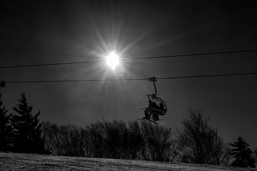 On ski lift heading up mountain black and white silhouette Photograph by Dan Friend