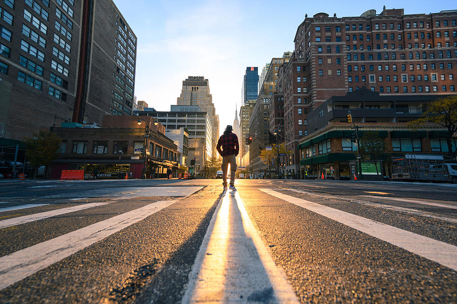 One person crossing a junction in Manhattan at sunrise, New York City Photograph by © Marco Bottigelli