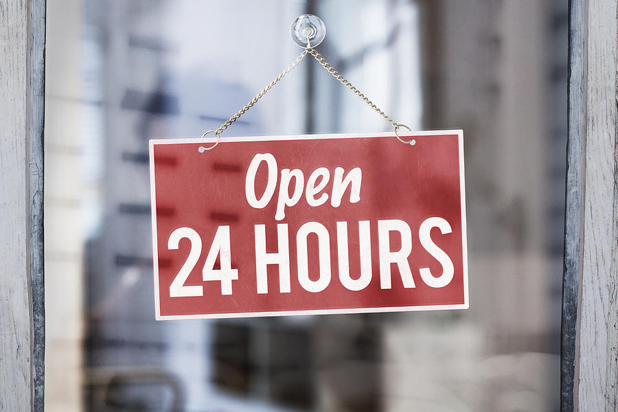 Open 24 hours sign on glass of shop door Photograph by Dimitri Otis