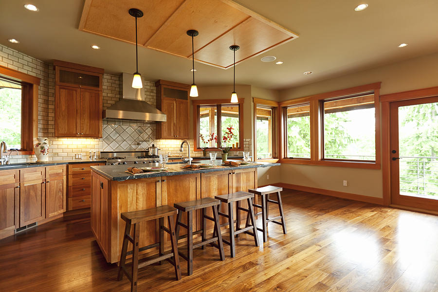 Open-plan kitchen with wooden cabinets and walnut floor Photograph by ChristinaKurtz
