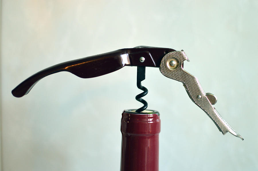 Opening bottle of wine with corkscrew Photograph by Luis Diaz Devesa