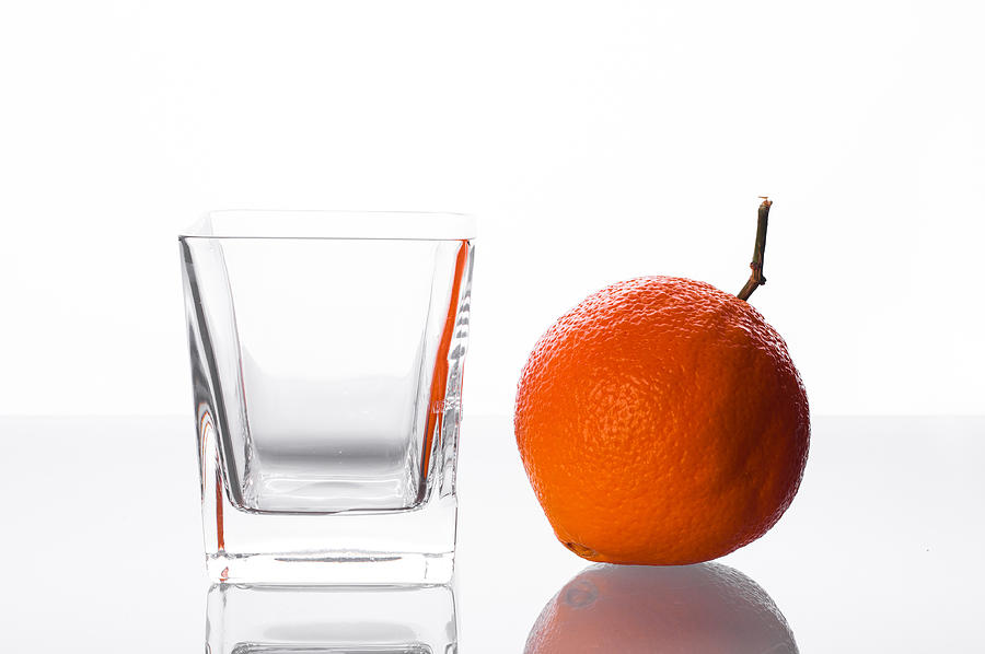 Orange and empty glass on table Photograph by MichalDziedziak