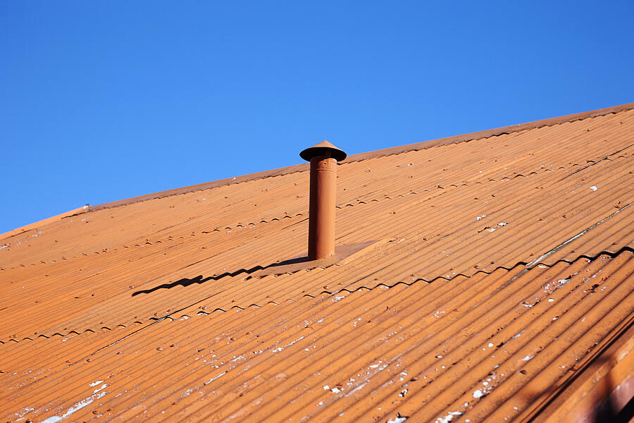 Orange painted metal corrugated roof and chimney Photograph by Joe Fox