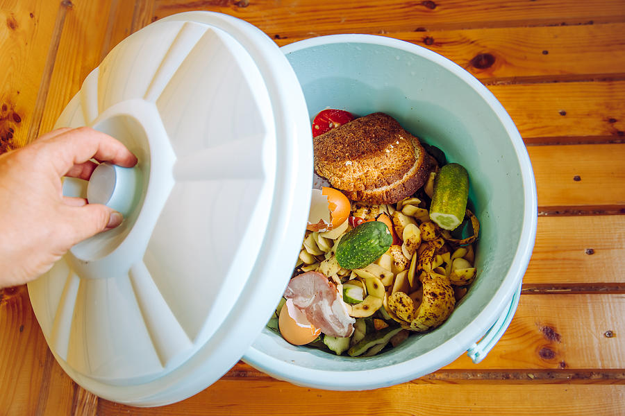Organic food waste in garbage bin bucket with lid in home on floor to be composted. Photograph by Helin Loik-Tomson