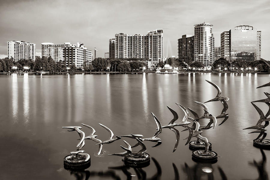 Orlando Skyline Photograph - Orlando Skyline and the Take Flight Sculptures on Lake Eola in Sepia by Gregory Ballos