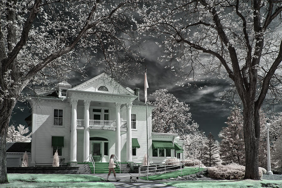 Out for a Stroll -  Cress funeral home and a dog walker in springtime and infrared spectrum Photograph by Peter Herman