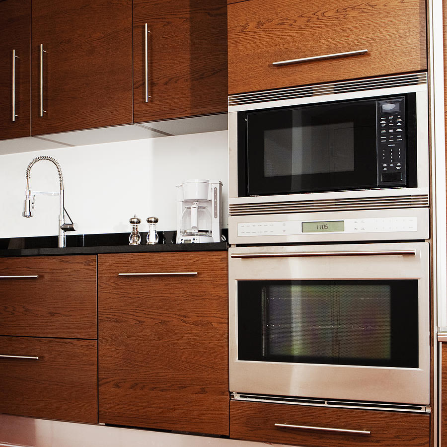 Oven, microwave, cabinets and sink in modern kitchen Photograph by Camilo Morales