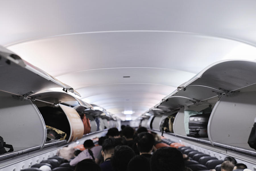 overhead locker on airplane,Passenger put cabin bag cabin on the top shelf. Travel concept Photograph by Jackyenjoyphotography
