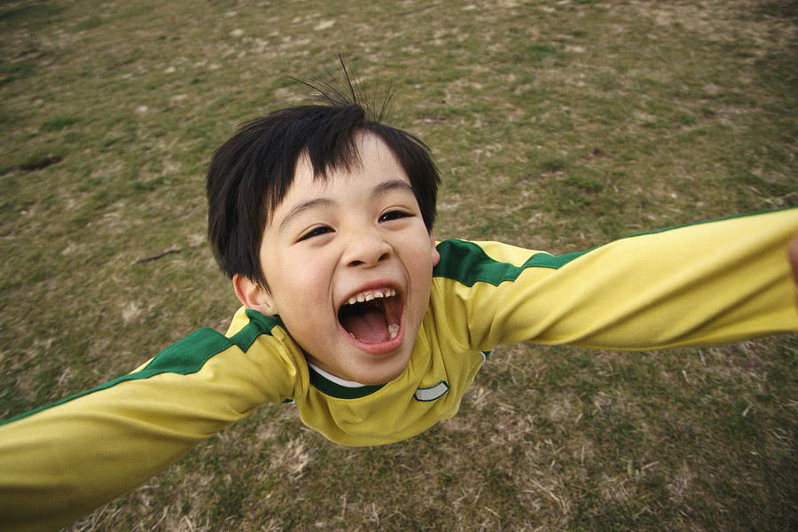 Overhead Shot of a Young Boy with His Arms Raised and His Mouth Open Photograph by Digital Vision.
