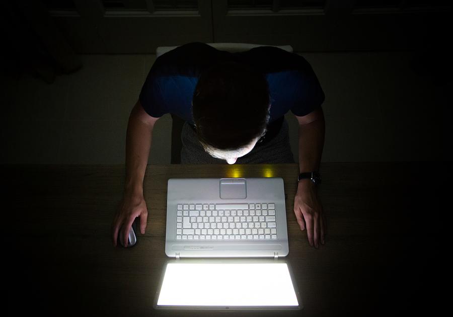 Overhead view of a man at dark night with laptop. Photograph by Artur Debat