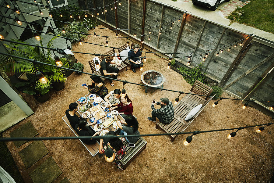 Overhead view of friends dining during backyard barbecue Photograph by Thomas Barwick