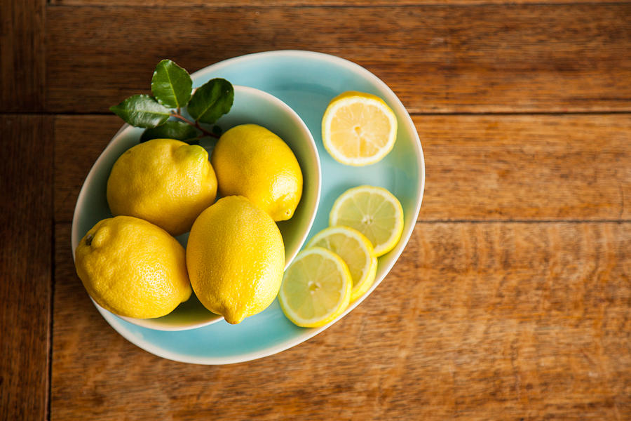 Overhead View Of Lemons In A Bowl On A Wooden Table Photograph by Claire Plumridge