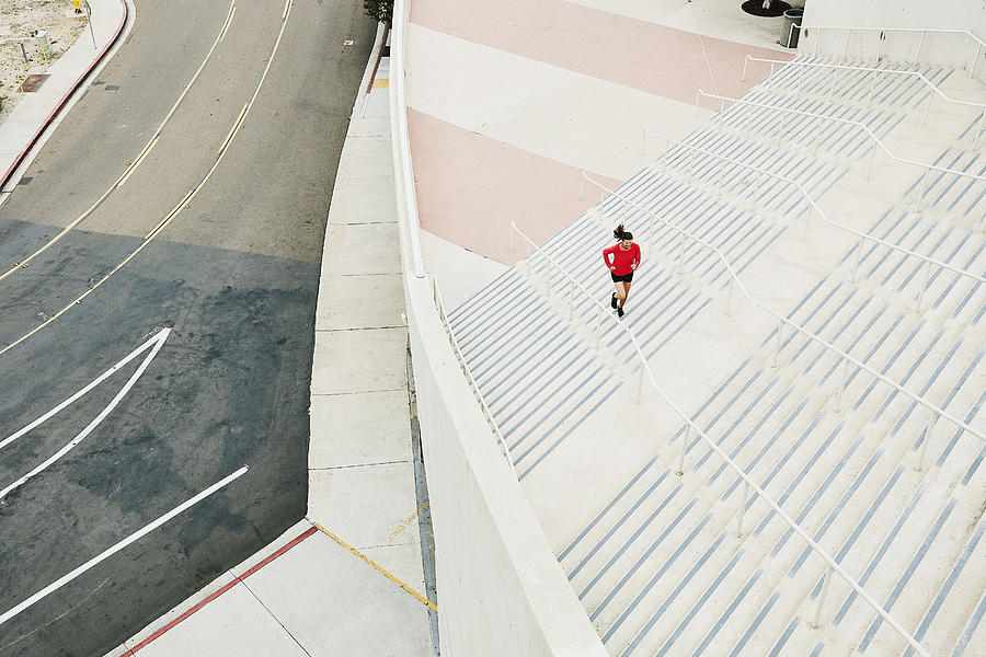 Overhead view of mature woman running stairs during workout Photograph by Thomas Barwick