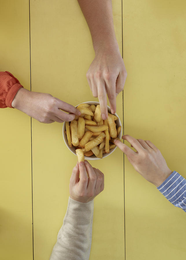 Overhead view of people sharing fries Photograph by Tim Macpherson