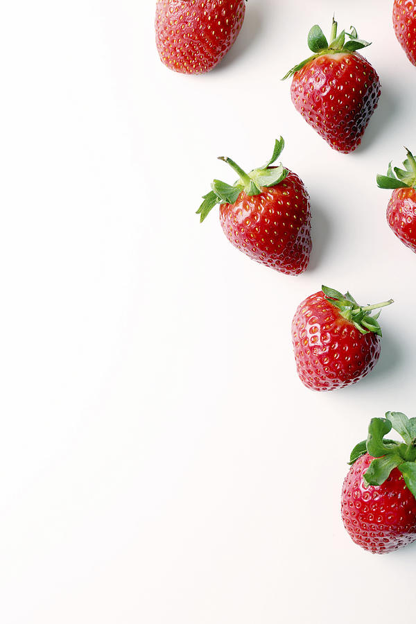 Overhead view of strawberries over white background Photograph by Cavan Images